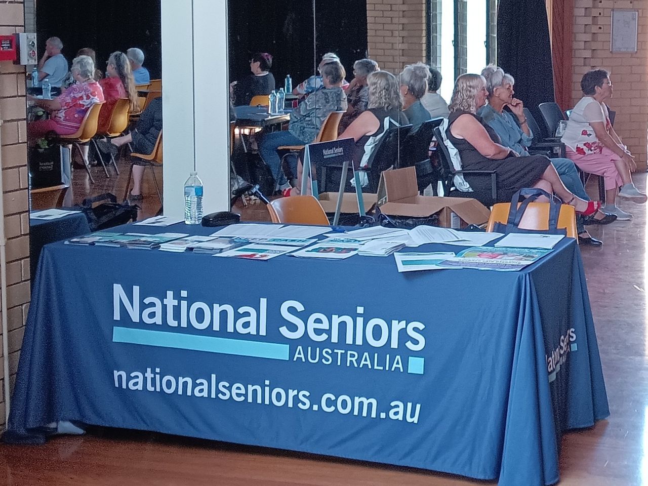 Seniors Forum and Childers Branch Launch Event 8/10/2025. National Seniors welcome table on the day filled with take home flyers sharing important information for seniors.